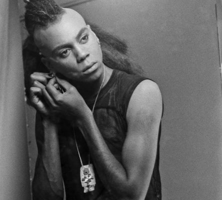 A young RuPaul looks into the mirror to prepare his makeup for a photoshoot in his Atlanta apartment in 1996.
